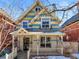 Charming blue and yellow two-story home with a welcoming front porch and intricate architectural details at 2336 N High St, Denver, CO 80205