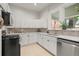 Bright kitchen with white cabinets, tile backsplash, stainless steel appliances, and a large window at 2336 N High St, Denver, CO 80205