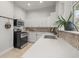 Kitchen features white cabinets, tile backsplash, stainless steel appliances, and a large window at 2336 N High St, Denver, CO 80205