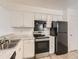 Kitchen with white cabinets and black appliances at 7185 S Gaylord St # G13, Littleton, CO 80122