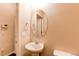 Powder room with pedestal sink, oval mirror, and neutral walls in a well-lit, cozy, and modern space at 2346 Central Park Blvd, Denver, CO 80238
