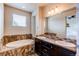 Bathroom with a soaking tub, dual sinks, and a dark wood vanity at 2346 Central Park Blvd, Denver, CO 80238