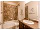 Full bathroom with a shower-tub combo and earth tone tile at 2346 Central Park Blvd, Denver, CO 80238