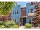 Contemporary blue townhouse with brick accents, a small balcony, and lush landscaping creating inviting curb appeal at 2346 Central Park Blvd, Denver, CO 80238