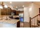 Stylish kitchen features dark wood cabinets, granite countertops, stainless steel appliances, and hardwood floors at 2346 Central Park Blvd, Denver, CO 80238