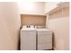 Laundry area with a white, front-loading washer and dryer, and shelf at 2346 Central Park Blvd, Denver, CO 80238