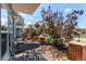 Outdoor patio features iron table and chairs, gravel ground cover, a grill and beautiful trees at 2346 Central Park Blvd, Denver, CO 80238