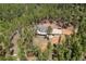 Aerial view of beautiful home surrounded by lush forest with a long driveway and plenty of land at 510 Hill Dr, Sedalia, CO 80135
