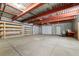 Unfinished basement with concrete flooring, exposed ceiling, shelving and an exterior door at 510 Hill Dr, Sedalia, CO 80135