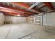 Unfinished basement with concrete flooring, exposed ceiling with red steel beams and shelving at 510 Hill Dr, Sedalia, CO 80135