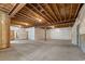 Unfinished basement with concrete flooring, exposed wood ceiling, and an exterior door at 510 Hill Dr, Sedalia, CO 80135