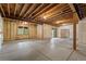 Unfinished basement with concrete flooring, exposed wood ceiling, and a window with a view of trees at 510 Hill Dr, Sedalia, CO 80135
