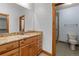 Bathroom vanity featuring granite countertops, wood cabinets, with a doorway into a toilet/shower room at 510 Hill Dr, Sedalia, CO 80135