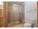The bathroom showcases a glass shower with bronze fixtures, a toilet and a vanity with wood cabinets at 510 Hill Dr, Sedalia, CO 80135