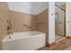 Bathroom featuring a white tub, grab bars, and a separate glass-enclosed shower stall at 510 Hill Dr, Sedalia, CO 80135