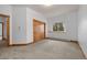 A bright bedroom featuring carpet, a window with a view of trees, and a wooden double sliding door closet at 510 Hill Dr, Sedalia, CO 80135