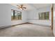 Bedroom featuring two windows overlooking a forest and a ceiling fan at 510 Hill Dr, Sedalia, CO 80135