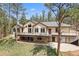 Spacious stucco home featuring an expansive deck with metal railings, surrounded by a lush green lawn and mature trees at 510 Hill Dr, Sedalia, CO 80135