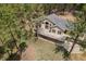 Aerial view of a charming home featuring an expansive deck, mature trees, and a sprawling yard at 510 Hill Dr, Sedalia, CO 80135