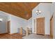 Welcoming foyer with hardwood floors, wood ceiling, staircase and a charming chandelier at 510 Hill Dr, Sedalia, CO 80135