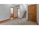 Hallway featuring wooden trim and doorways, a staircase and a carpeted floor at 510 Hill Dr, Sedalia, CO 80135