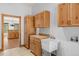 Laundry room with cabinets and sink, next to an open doorway into a kitchen area at 510 Hill Dr, Sedalia, CO 80135