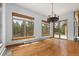 Bright living room with wood floors, chandelier and large windows boasting scenic wooded views at 510 Hill Dr, Sedalia, CO 80135