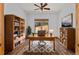 Inviting home office featuring custom bookshelves, a large window, and ceiling fan at 510 Hill Dr, Sedalia, CO 80135