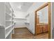 A spacious walk-in closet with custom shelves that connect to a bathroom with wood cabinets and granite counter tops at 510 Hill Dr, Sedalia, CO 80135