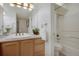 Bright bathroom with a shower-tub combo and a vanity with a blond cabinet at 9160 E Arbor Cir # F, Englewood, CO 80111