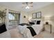 The bedroom features a ceiling fan, a sliding glass door that leads to a balcony, and modern decor at 9160 E Arbor Cir # F, Englewood, CO 80111