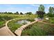 Scenic community park with a pond, stone walkways, and shaded lounge areas at 9160 E Arbor Cir # F, Englewood, CO 80111