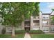 Multi-story condo building with stone accents, balconies, and lush landscaping at 9160 E Arbor Cir # F, Englewood, CO 80111