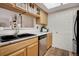 Well-lit kitchen features wood cabinets, stainless steel appliances, and a black double basin sink at 9160 E Arbor Cir # F, Englewood, CO 80111