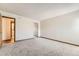 Spacious bedroom with neutral carpet, closet with mirrored doors, and en-suite bathroom at 3315 S Ammons St # 111, Lakewood, CO 80227