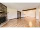 Open-concept living room featuring a fireplace and wood floors, flowing into the kitchen area at 3315 S Ammons St # 111, Lakewood, CO 80227