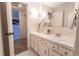 Well-lit bathroom featuring a vanity with drawers and countertop space, a mirror, and neutral tones at 6420 E Bates Ave, Denver, CO 80222