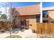 Charming home exterior with tile roof, secured entry, and privacy fence at 6420 E Bates Ave, Denver, CO 80222