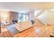 Bright living room with hardwood floors, stone fireplace, and staircase at 6420 E Bates Ave, Denver, CO 80222