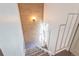 View of a carpeted staircase with white railings and a wood paneled wall with accent lighting at 6420 E Bates Ave, Denver, CO 80222