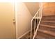 Stairway featuring carpeted stairs with white handrail and tile landing at 6420 E Bates Ave, Denver, CO 80222