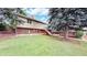 A lovely backyard with a spacious lawn, brick exterior, and elevated deck at 8663 E Davies Ave, Centennial, CO 80112