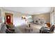 An open living space featuring hardwood floors and access to an eat-in kitchen and a red front door at 8663 E Davies Ave, Centennial, CO 80112