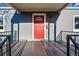 Inviting red front door with decorative glass, framed by a covered porch and black iron railings at 4720 Perry St, Denver, CO 80212