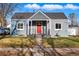 Welcoming home with a vibrant red front door and a charming, covered front porch at 4720 Perry St, Denver, CO 80212