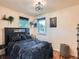 Bedroom featuring modern bed, black accents, two windows, wooden floors, and plants at 3645 S Fox St, Englewood, CO 80110