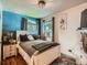 Bedroom with a modern bed, two windows, unique decorations, and a blue accent wall at 3645 S Fox St, Englewood, CO 80110