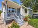 Inviting covered front porch with seating, fresh landscaping, and brick walkway to the home's entrance at 3645 S Fox St, Englewood, CO 80110