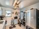 Cozy kitchen with stainless steel refrigerator and appliances plus a rustic wooden light fixture at 3645 S Fox St, Englewood, CO 80110