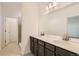 Bathroom featuring dual sinks, a large mirror and dark wood cabinets at 747 Sunflower Dr, Brighton, CO 80601